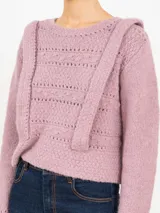 Sweater tejido color rosa con cuello redondo y mangas largas. Presenta apliques de tablas en los hombros y en el frente.