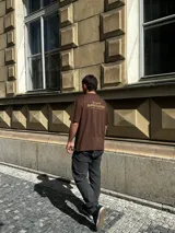 Remera marrón de corte oversize con estampado pequeño en el pecho.