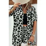 Conjunto de dos piezas compuesto por una camisa de manga corta con cuello italiano y cierre frontal de botones, y un short con cintura elástica y bolsillos laterales. Ambas prendas presentan un diseño estampado de animal print.