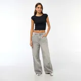 Jean de corte baggy y tiro bajo, color gris con efecto lavado y detalles de roturas en las piernas. Cuenta con diseño clásico de cinco bolsillos y cierre frontal con botón y cremallera.