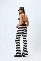 Pantalón tejido con motivo zigzag en blanco y negro, de corte flare y cintura elastizada.