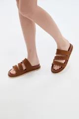 Sandalias planas marrones con múltiples tiras cruzadas y detalles de costuras decorativas.