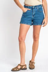 Short de denim azul de tiro medio, con bolsillos delanteros y traseros, cierre de botón y cremallera, y botamangas con dobladillo.