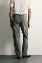 Pantalón jeans de corte recto, color celeste claro con efecto lavado, de cinco bolsillos y tiro medio.