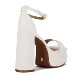 Sandalia de plataforma alta color blanco, con tira ancha en la parte delantera del pie y tira fina ajustable con hebilla en el tobillo. Posee taco ancho y alto.