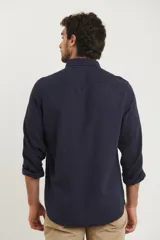 Camisa de manga larga con cuello abotonado y bolsillo frontal, confeccionada en una mezcla de algodón y lino.