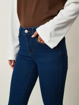 Jean de corte bootcut color azul oscuro, con tiro medio, bolsillos clásicos y cierre frontal con botón y cremallera.