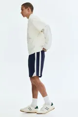 Short de baño azul marino con bandas laterales blancas, cintura elástica con cordón de ajuste blanco y dobladillo curvo.