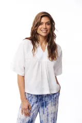 Blusa blanca de algodón con escote en V y mangas cortas amplias.