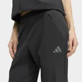Pantalón de entrenamiento Adidas Tech Intensity de color negro, corte clásico con cintura elástica de talle medio, bolsillos con cierre y logo Performance estampado en el mismo tono.