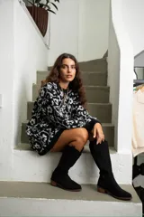 Vestido corto de tejido de punto con diseño oversize, cuello redondo y mangas largas con puños acanalados. Presenta un estampado floral en tonos blanco y celeste.