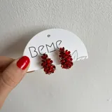 Aros colgantes con diseño de racimo de pequeñas flores rojas con centro brillante.