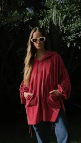 Canguro oversize de plush rojo con capucha, mangas abullonadas y amplios bolsillos frontales tipo parche.