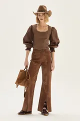 Pantalón wide leg de cuero sintético color marrón, con tajo frontal en el ruedo y cierre de botón y cremallera.
