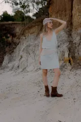 Bandana tejida a crochet con diseño triangular y terminaciones en cordones para anudar. Es un accesorio versátil que puede utilizarse como cinturón o como pañuelo para la cabeza.