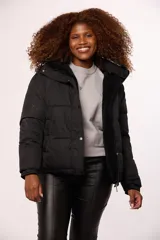 Campera reversible para mujer, con un lado de nylon acolchado y el otro de corderito sintético. Cuenta con cierre frontal, capucha y diseño de corte recto.