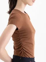 Remera de morley con escote redondo, mangas cortas y detalle de frunce en los laterales.