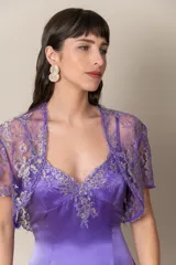 Vestido largo de satén color violeta, con breteles finos y apliques de encaje al tono con hilos dorados. Incluye bolero de encaje.
