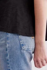 Remera básica de corte holgado, manga corta y cuello redondo, confeccionada en algodón peruano con textura jaspeada de color morado. Presenta un diseño de largo irregular con ruedo redondeado.