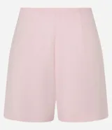Short pollera de sastrería color rosa pálido, con cintura fija, corte corto, detalle de encaje en el frente y cierre lateral oculto.
