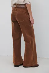 Jean de corte wide leg en color bordó, con costuras a contratono y diseño de cinco bolsillos.