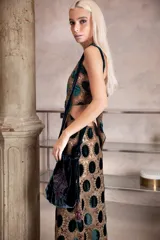 Vestido largo de encaje con diseño de círculos de terciopelo verde, con escote halter que se ata en la nuca y espalda descubierta con ajuste en la cintura.