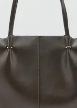 Bolso tipo shopper de efecto piel en color marrón oscuro, con diseño estructurado, doble asa de hombro y cierre de botón magnético.