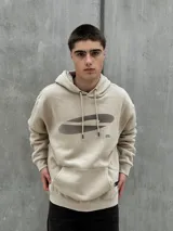 Canguro beige con capucha ajustable con cordones, bolsillo tipo canguro y estampado con diseño abstracto en negro.