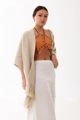 Top tipo halter de cuero color camel, con diseño de piezas orgánicas, perforaciones metálicas y detalles de tientos cruzados. Presenta un escote abierto y estructura firme.