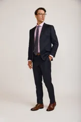 Ambo de vestir para hombre compuesto por saco de dos botones y pantalón de corte recto, en color azul marino. El saco presenta solapas clásicas y bolsillos con solapa, mientras que el pantalón cuenta con un ajuste entallado.