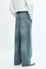 Jeans de cinco bolsillos en denim de algodón rígido, color celeste claro con efecto desgastado/lavado. Modelo de corte super holgado (baggy) desde la cadera hasta el tobillo, con piernas redondeadas extraamplias y tiro bajo.