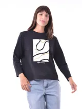 Remera de manga larga color beige, con cuello redondo y estampado frontal que dice "Magic is something you make" en color lila.