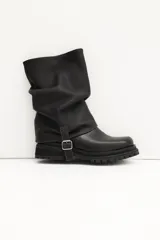 Bota corta de cuero color marrón claro (visón) con caña arrugada y suela track negra gruesa. Presenta un detalle de tira de cuero con hebilla en el tobillo.