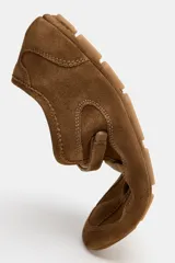 Bailarina deportiva de serraje color marrón, con diseño de doble tira en el empeine, una elástica y otra con cierre adhesivo. Presenta costuras decorativas en el cuerpo, suela plana y punta redonda.