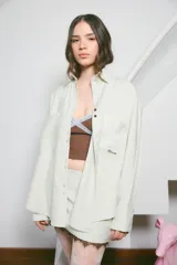 Camisa oversize color marrón, confeccionada en twill, con bolsillos irregulares y bordado 'munay' a contratono.