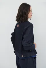 Chaqueta de pana color azul oscuro, con cuello camisero, cierre frontal con botones y bolsillos laterales. Diseño de corte recto y manga larga.