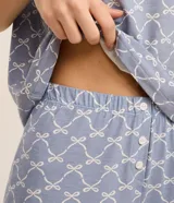 Short de pijama confeccionado en viscosa de color celeste con estampa de lacitos blancos y detalle de encaje en el ruedo.
