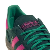 Championes Adidas Handball Spezial de gamuza verde oscuro, con las tres franjas laterales y el talón en fucsia. Presenta la inscripción dorada "SPEZIAL" en el lateral, suela de goma caramelo y cordones verdes.