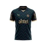 Camiseta de fútbol Puma del Club Atlético Peñarol, modelo Third Jersey 26. Diseño en tonos oscuros con patrón geométrico en zigzag, detalles en color dorado en cuello, mangas y logos. Incluye escudo del club, logo de Puma y sponsor Antel en el frente.