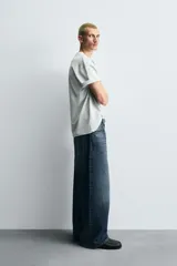 Jeans de denim de algodón, color azul oscuro con efecto lavado. Presentan un corte muy holgado (baggy fit) en toda la pierna y tiro medio. Tienen cinco bolsillos y cierre frontal con cremallera y botón.