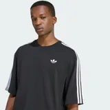 Camiseta oversize Adidas Adicolor de color negro, confeccionada en tejido de punto simple de algodón. Presenta cuello redondo, mangas cortas con las icónicas tres rayas blancas y el logo Trefoil bordado en el pecho.