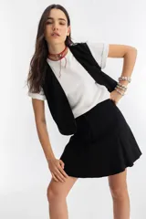 Minifalda negra de gamuza con cintura alta y godets.