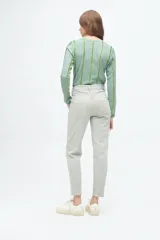 Pantalón tipo jean de corte recto y tiro medio, en color beige con sutiles rayas verticales en tonos tierra.