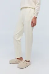 Pantalón de jogging color crema, de tela elastizada con bordados florales, corte recto y cintura elastizada.