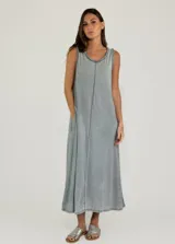 Vestido midi sin mangas de corte holgado, con cuello redondo y costura central vertical. Presenta detalles de terminación desflecada en el cuello y las sisas, y cuenta con bolsillos laterales.