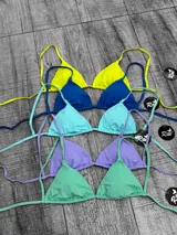 Corpiño de bikini tipo triángulo con copas removibles. Se ata en la espalda y tiene tiras ajustables que también permiten atarlo al cuello.