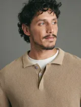 Remera de punto tipo polo con textura waffle, color verde petróleo, de manga larga y cuello con cierre de botones.