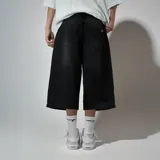 Bermuda de jean negro con corte ancho y largo a la rodilla.