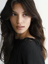 Sweater de punto negro con cuello redondo y detalle de lazo en los hombros.