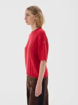 Buzo tejido de manga corta color rojo, con cuello redondo y diseño de punto acanalado y trenzado.